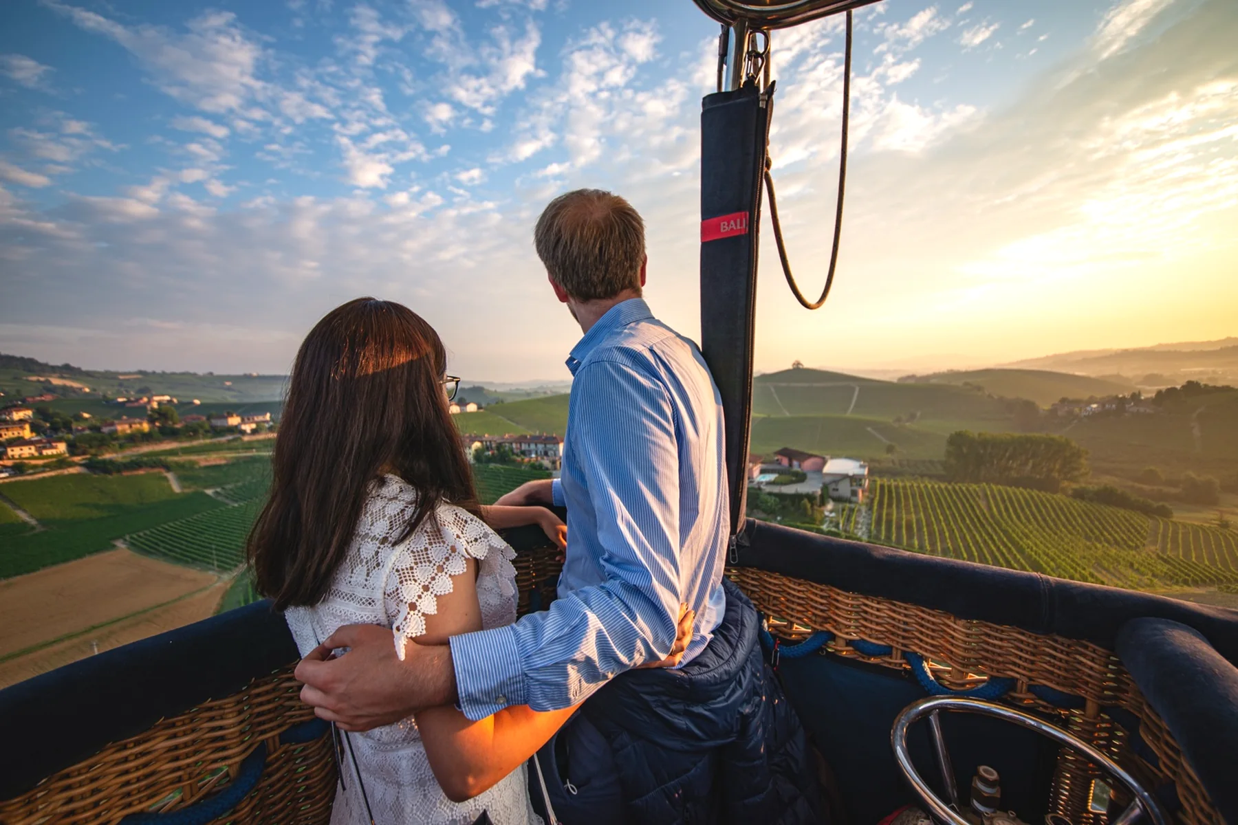 Una pareja contempla las colinas desde la cesta de un globo
